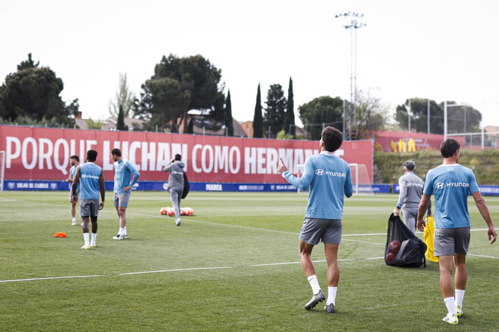 Jugadores del Atlético saltando al campo de entrenamiento.